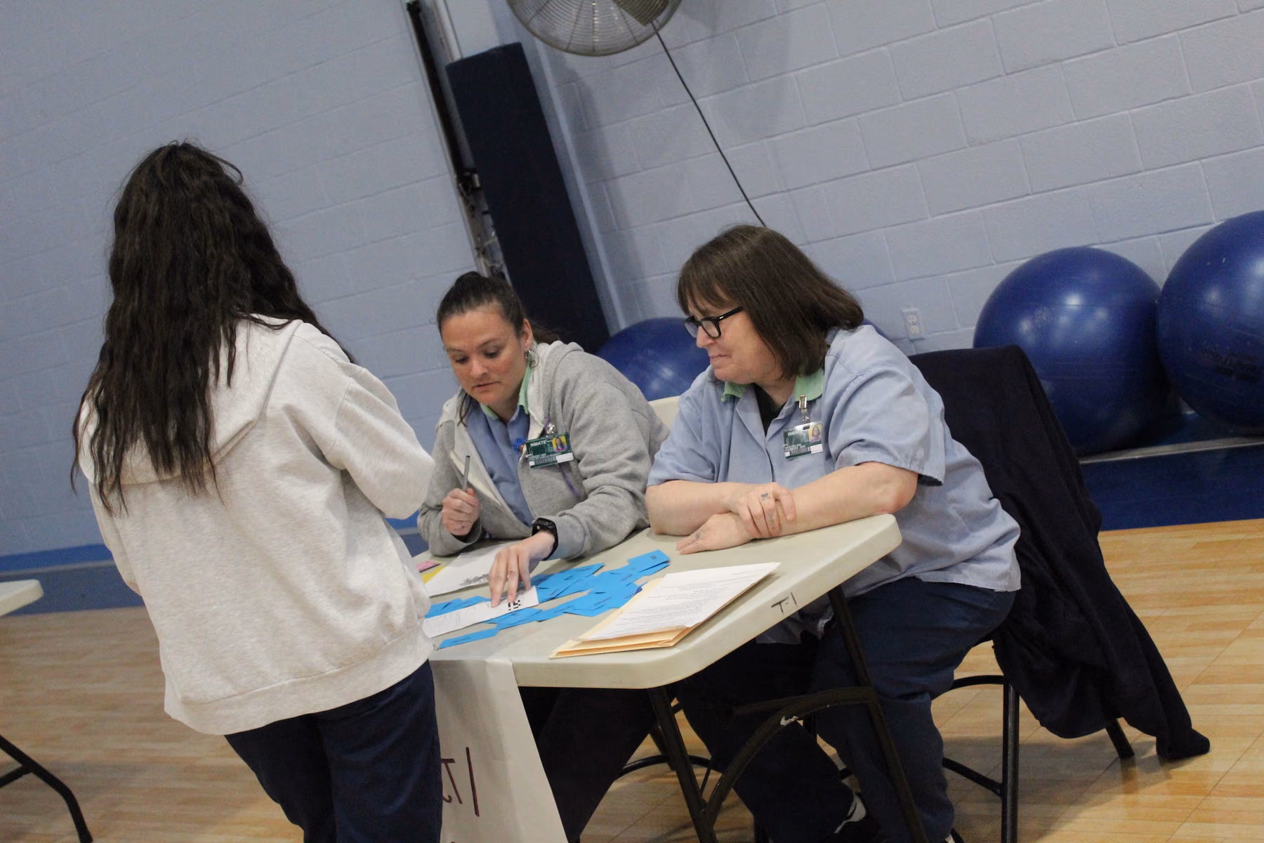 A participant visits a resource table staffed by volunteers during a Four-Seven reentry simulation.